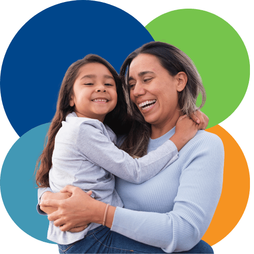 Woman with brown hair smiling and holding young girl in her arms Woman with brown hair smiling and holding young girl in her arms