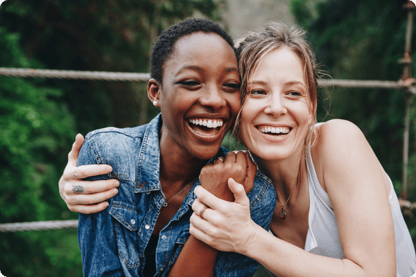two smiling women outside