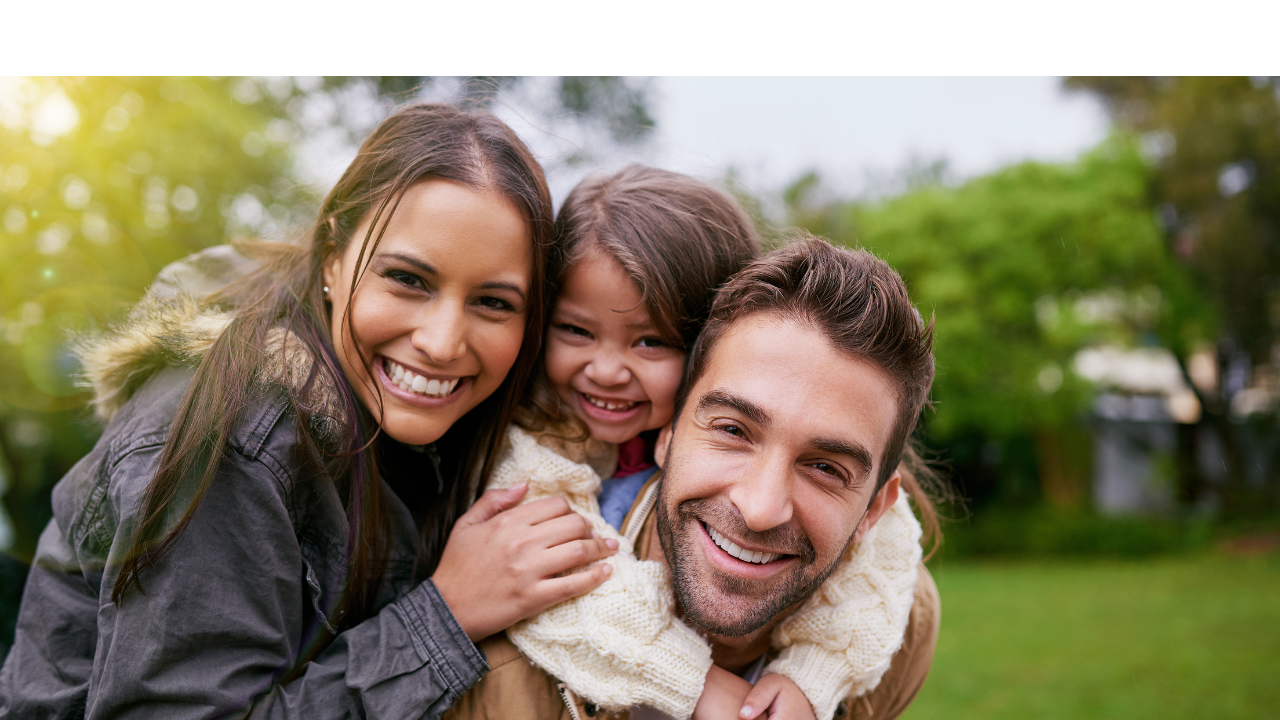 smiling family of two adults and little girl