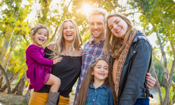 two adults and three girls outside smiling blonde hair