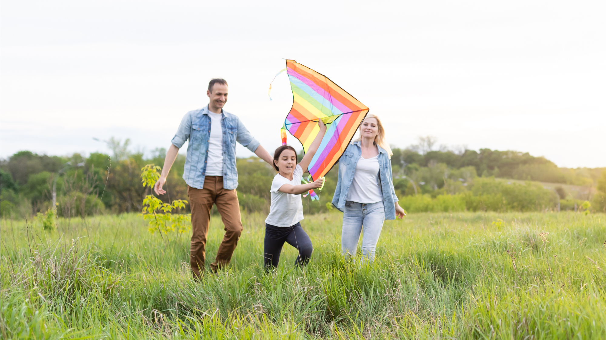 smiling parents and child outside with kite