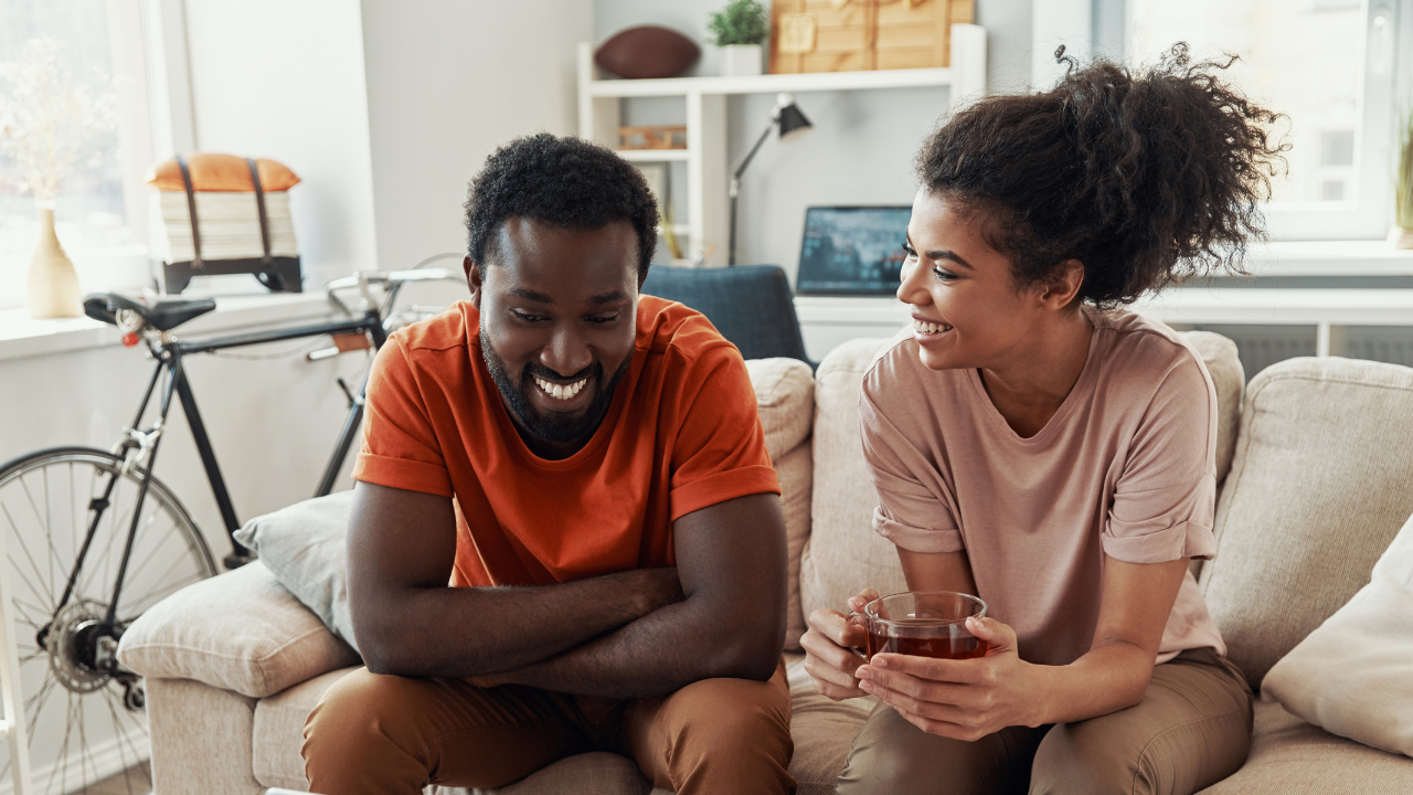African American couple smiling sitting on couch