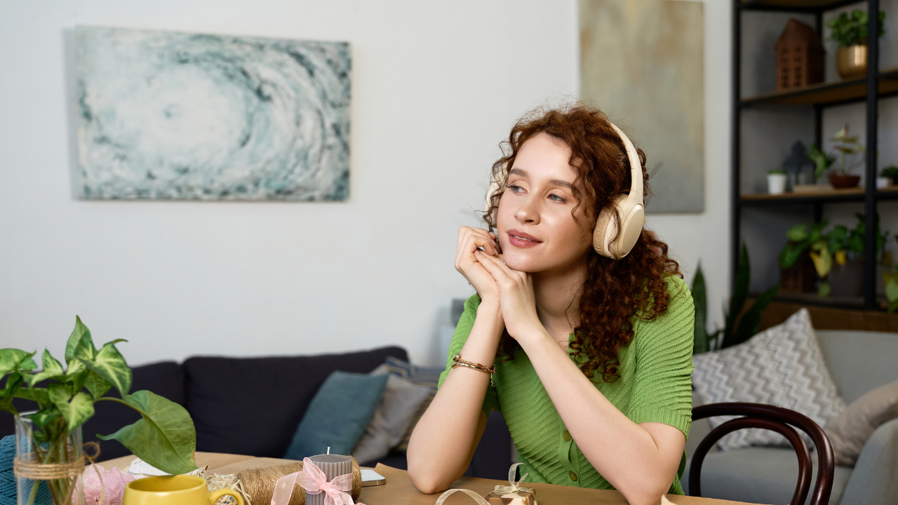 woman in green shirt smiling wearing headphones