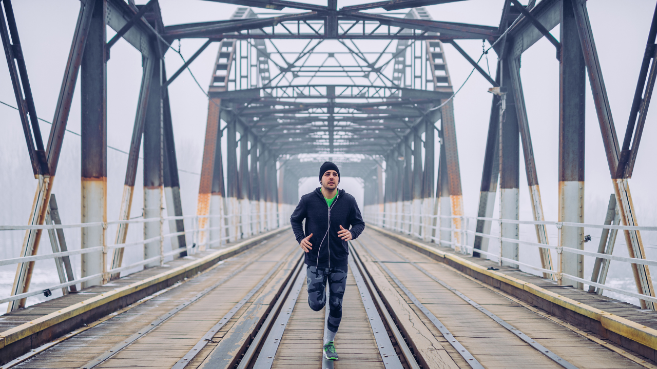 man running outside on bridge