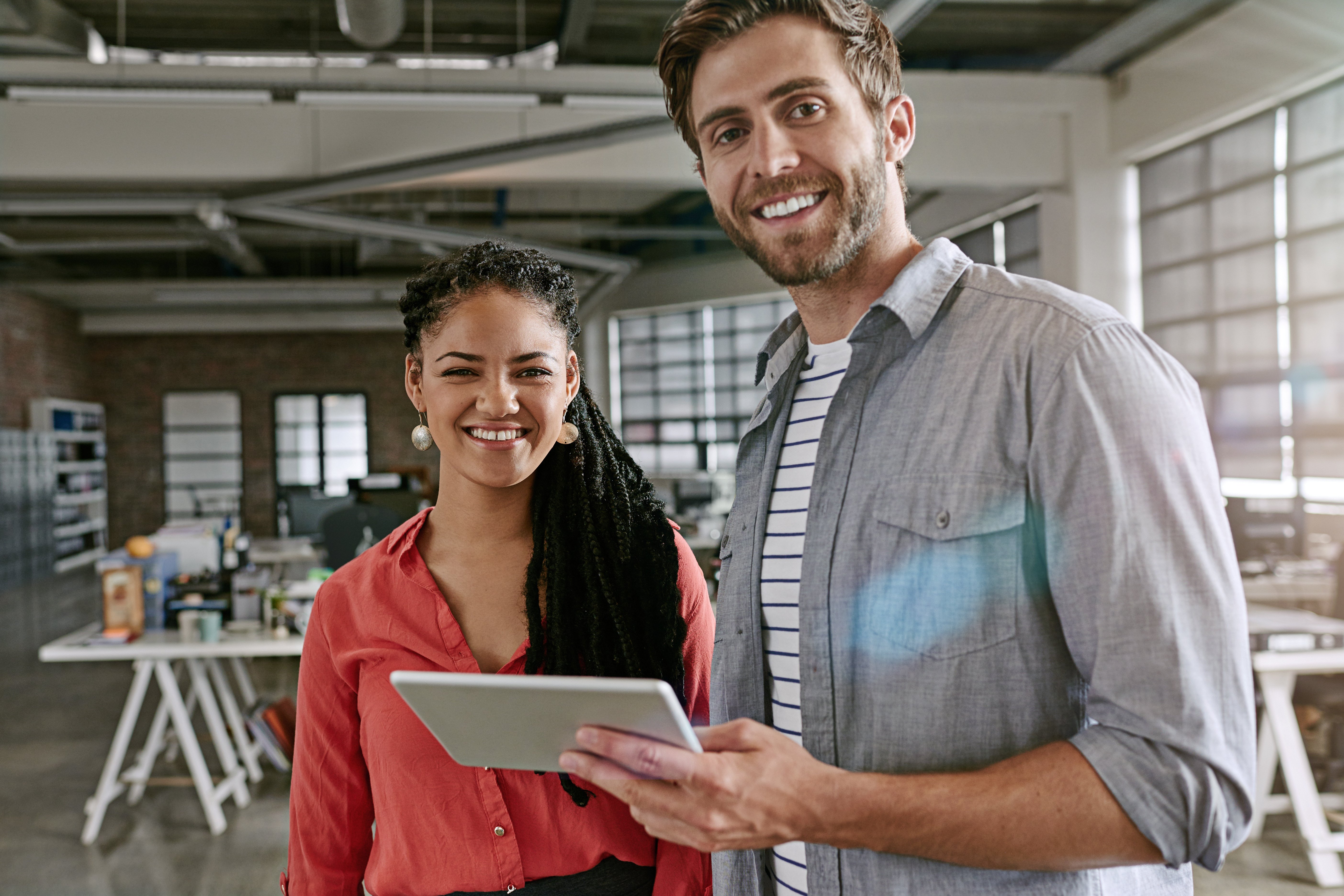 man and woman looking at tablet smiling